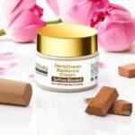 HerbOcean Radiance Cream jar with lotus petals and sandalwood blocks on white background showcasing Ayurvedic skin brightening cream